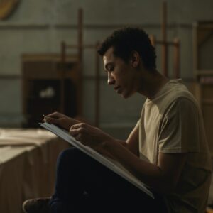 A Man Sketching On A White Cardboard