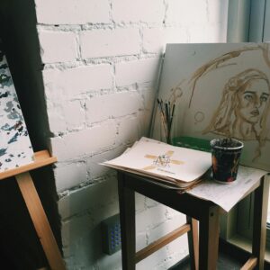 Creative artist workplace with drawings on easel